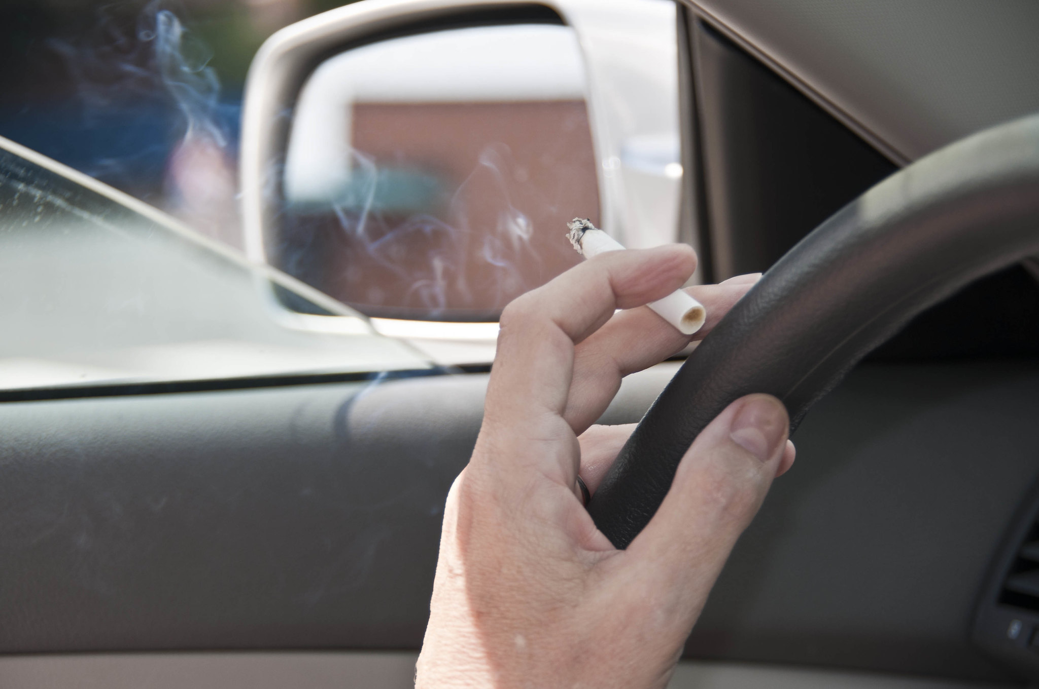 Можно курить в машине. Курит в машине. Курение в автомобиле. Швырнуть окурок из машины. Курение в каршеринге.